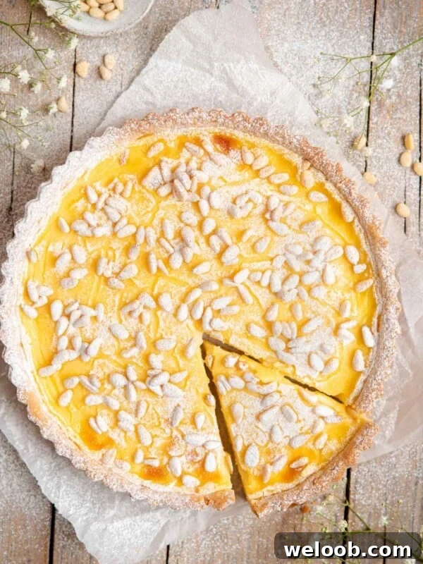 An overhead shot of torta della nonna on a rustic wooden surface