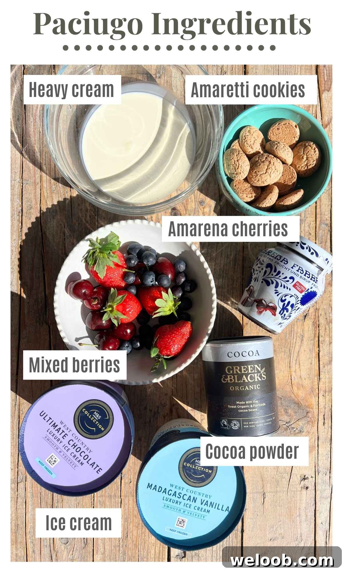 All the ingredients to make an Italian ice cream sundae laying on a rustic wooden surface; mixed berries, amarena cherries, heavy cream, ice cream, cocoa powder and amaretti cookies.