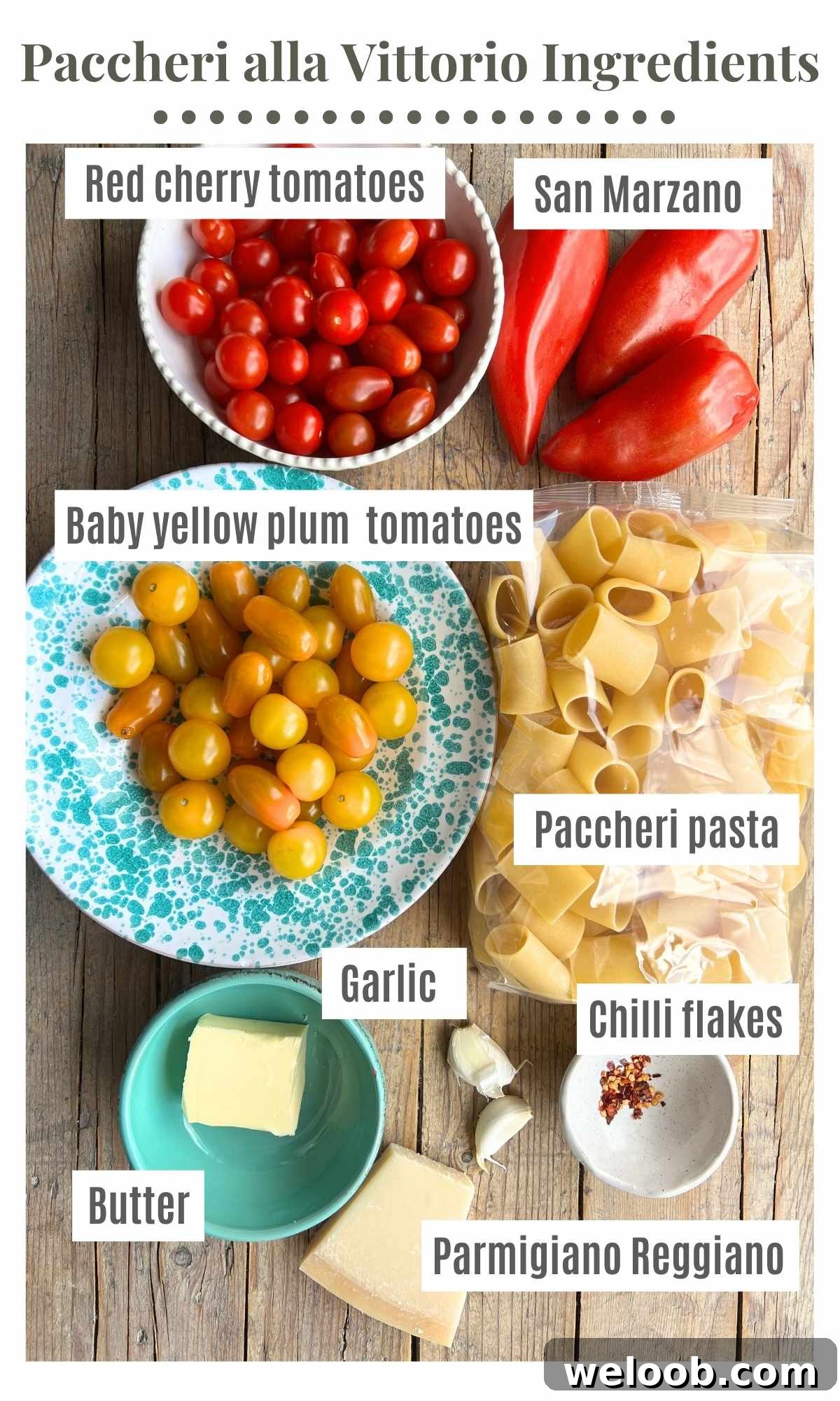 All the ingredients needed to make pasta alla vittorio on a wooden board; plum tomatoes, cherry tomatoes, butter, parmigiano reggiano, garlic, chilli flakes and paccheri pasta.