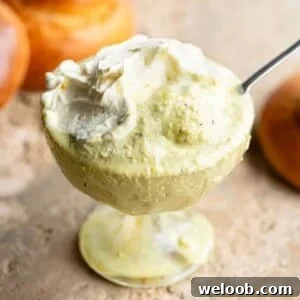 A close up of pistachio granita in a glass bowl with whipped cream on top.