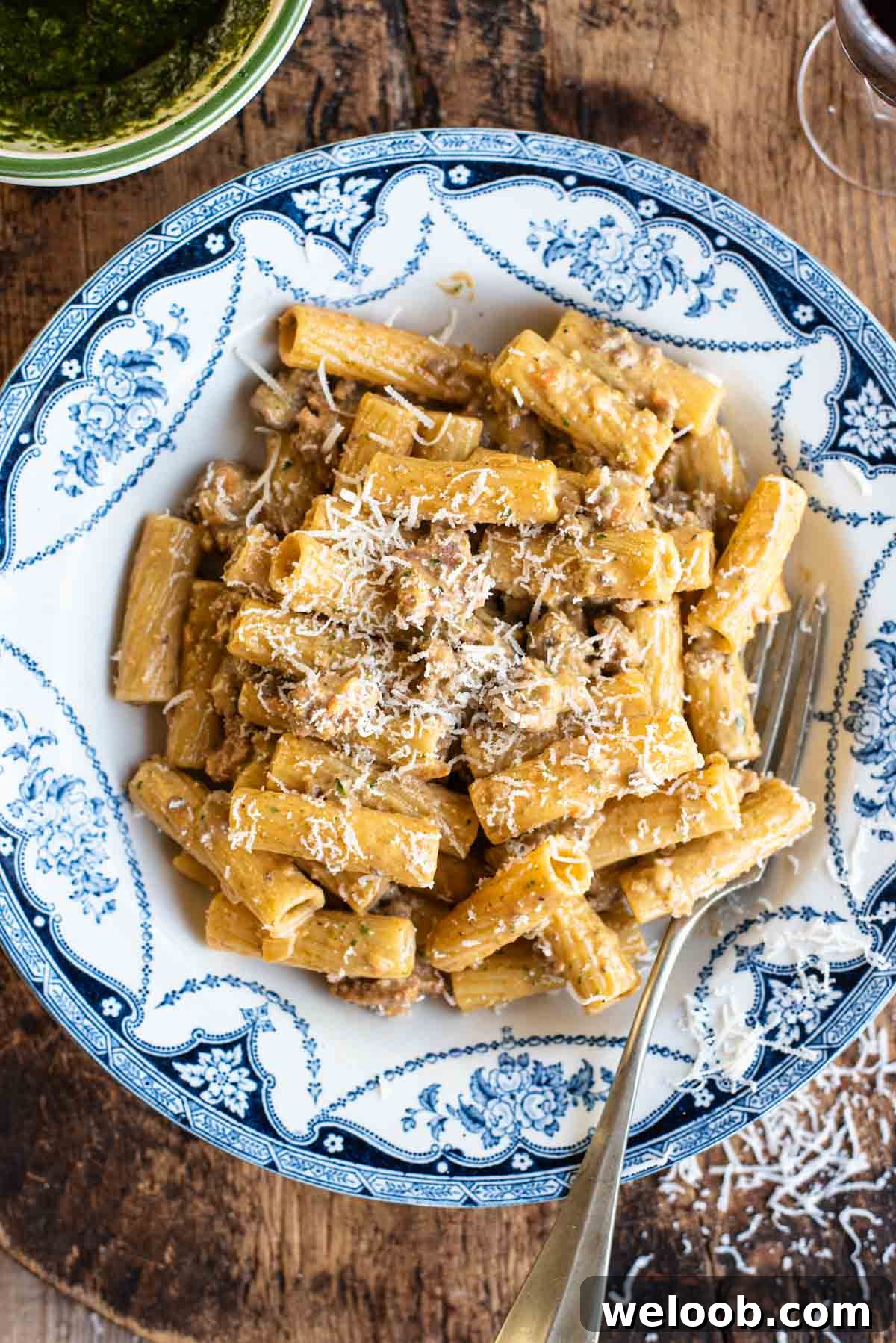 Pasta alla Montecarlo (creamy meat sauce) in a country style blue and white bowl sitting on a wooden chopping board.