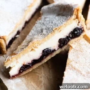 A close up of a a slice of ricotta and cherry tart.