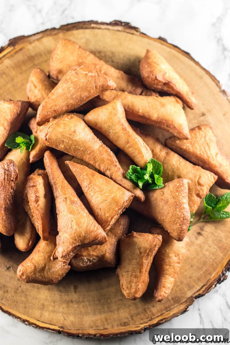 Mandazi on a brown serving platter.
