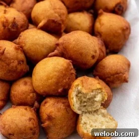 Banana fritters on a platter with one opened up to show texture