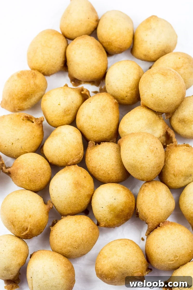 Cameroonian drop doughnuts on white parchment paper.