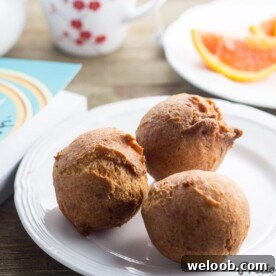 Three beignets souffles on a small plate.
