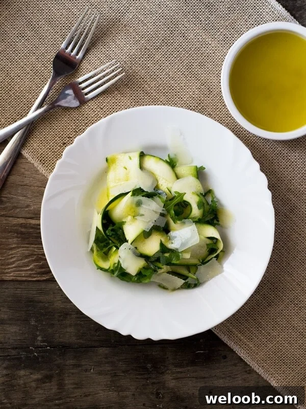A fresh, Summer Zucchini Ribbon Salad with a simple tart lemon dressing, arugula, and shavings of parmesan.