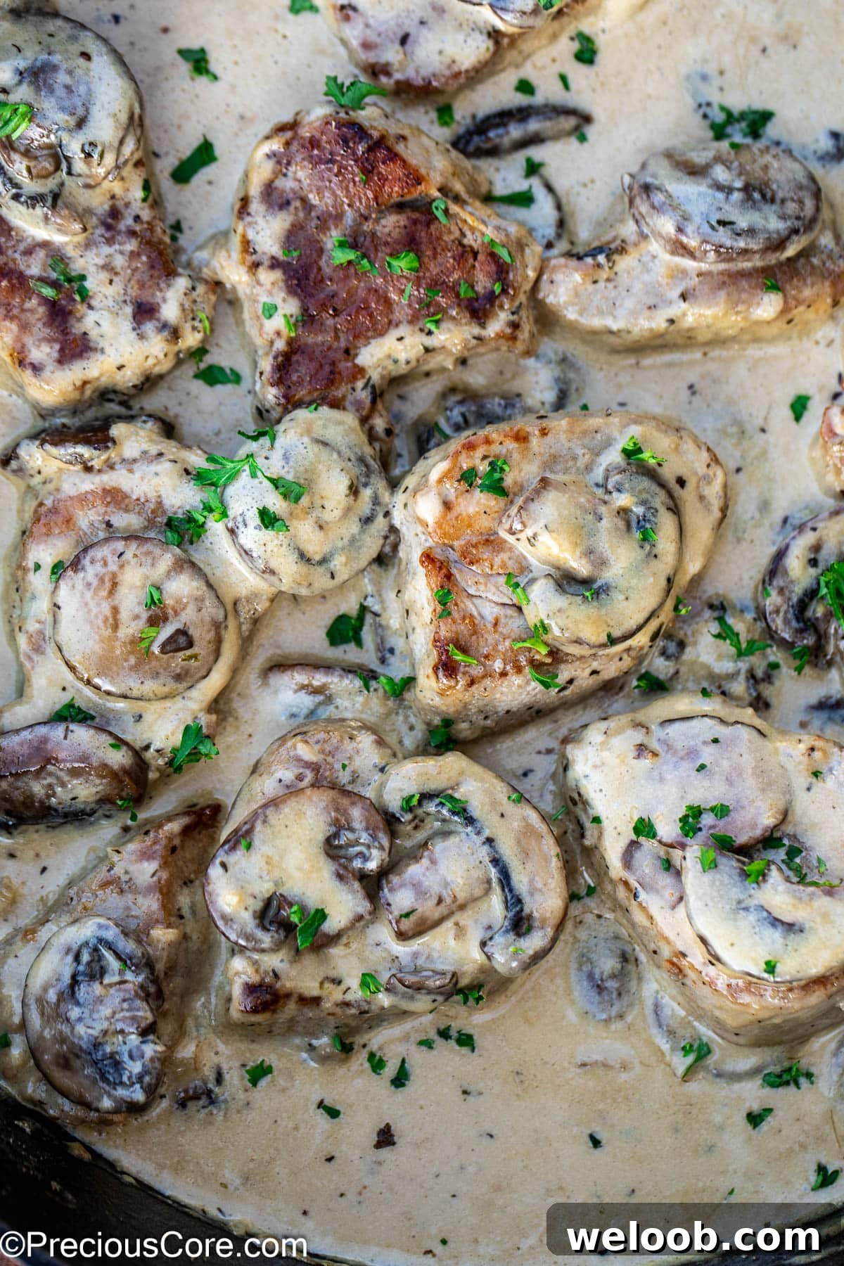 Pork medallions topped with mushrooms in a savory creamy sauce.