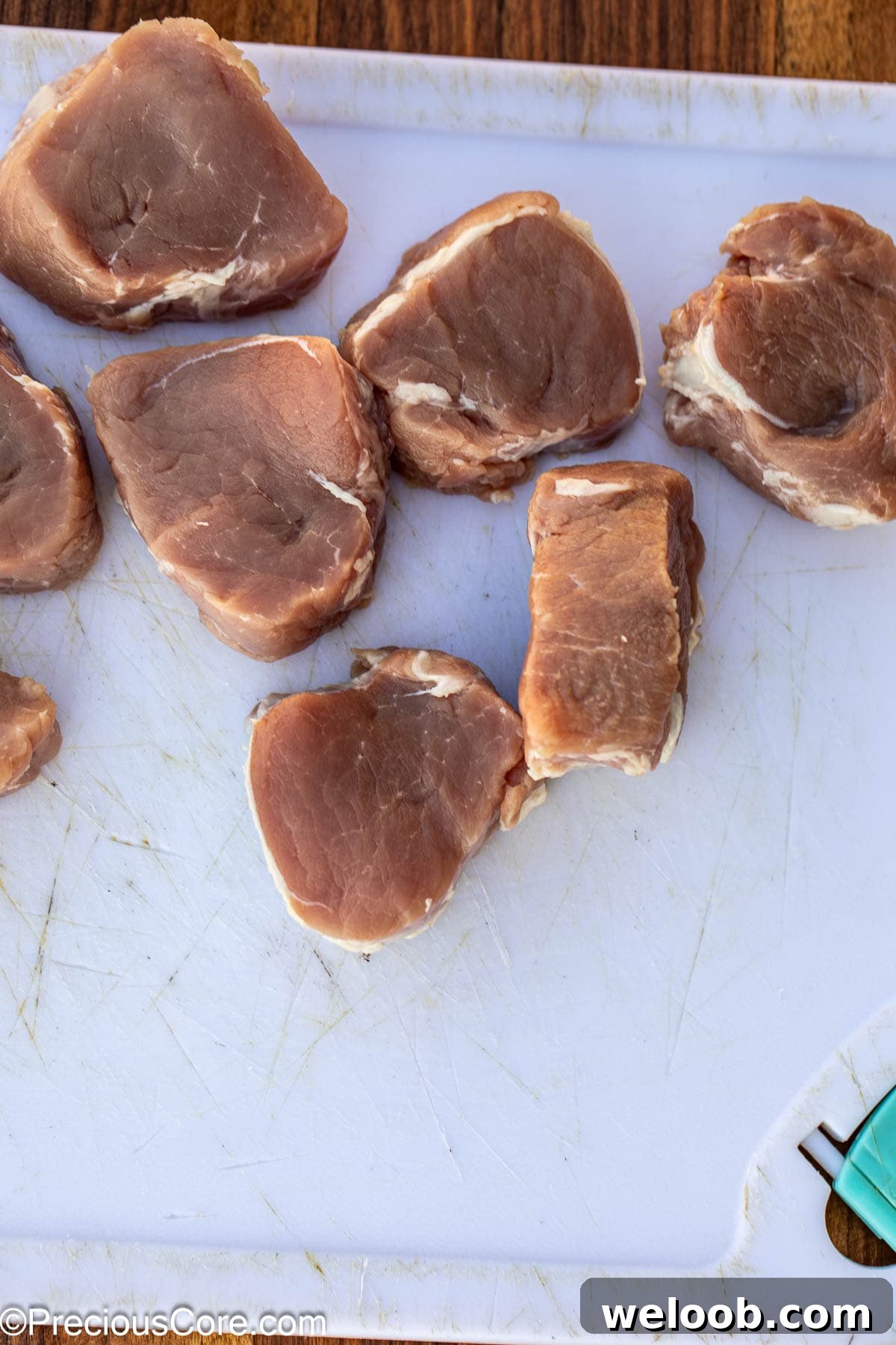 Sliced pork tenderloin on chopping board.