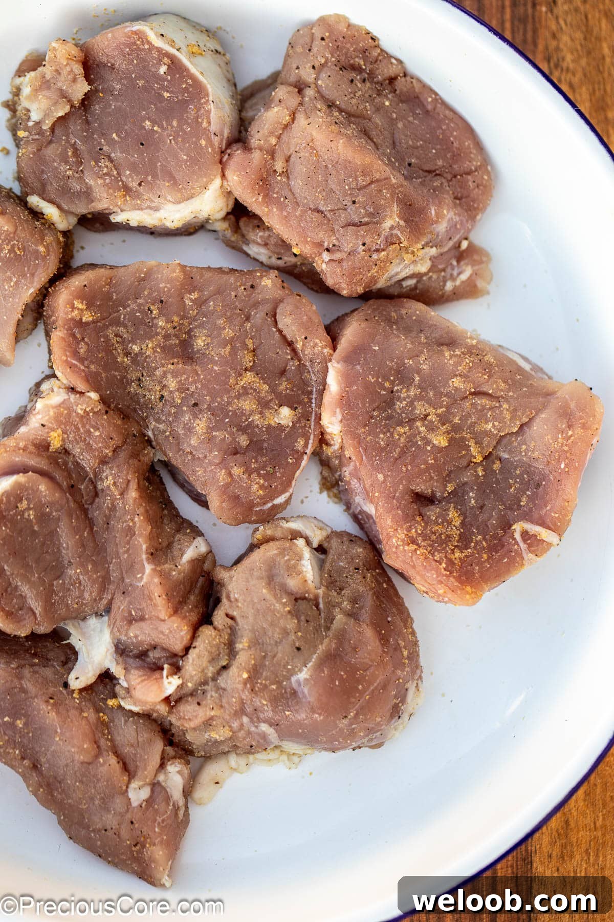 Seasoned pork medallions in a white bowl.