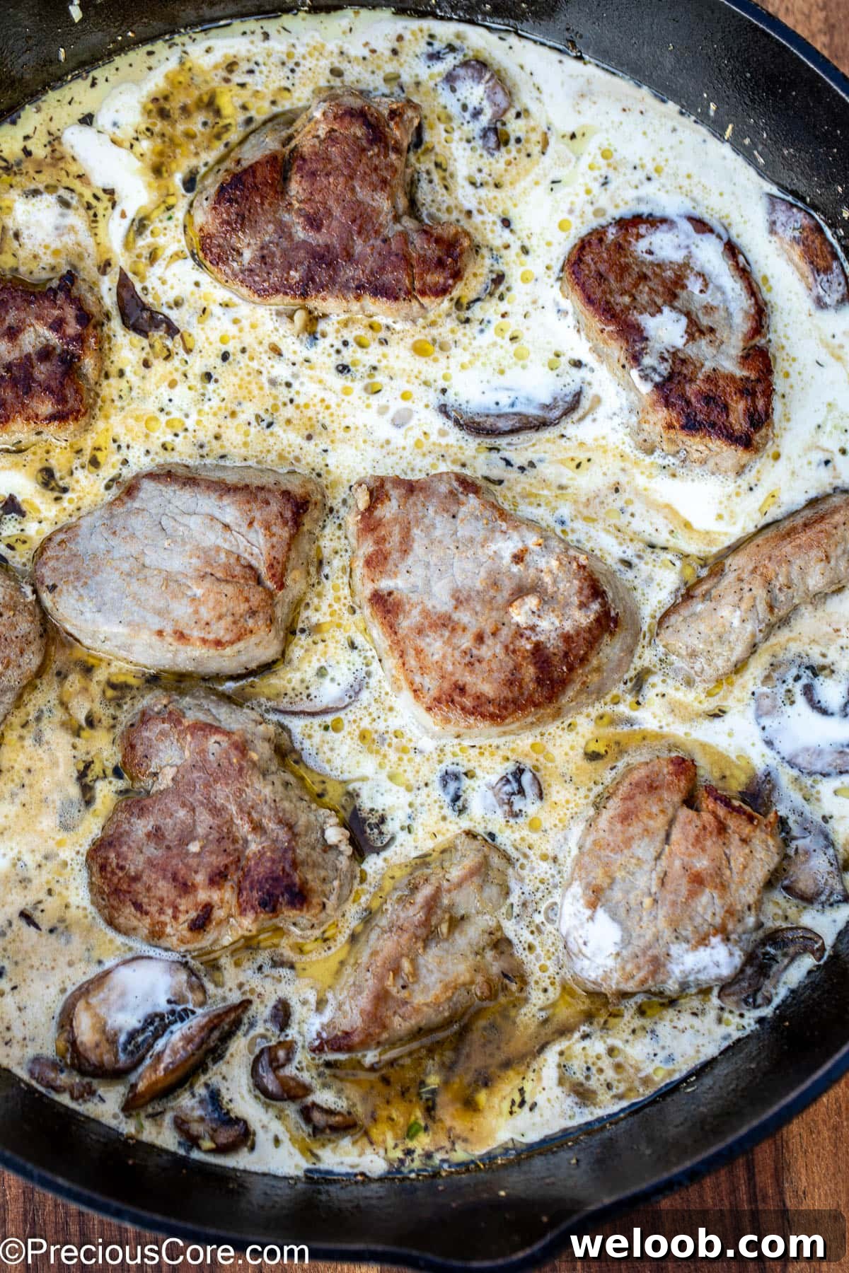 Sauce in a skillet with round slices of meat.