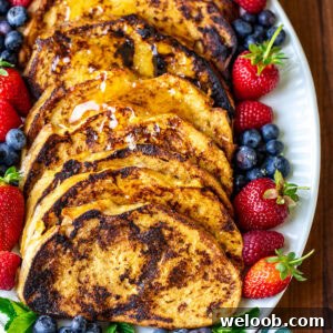 Slices of Sourdough French toast on a white oval plate.