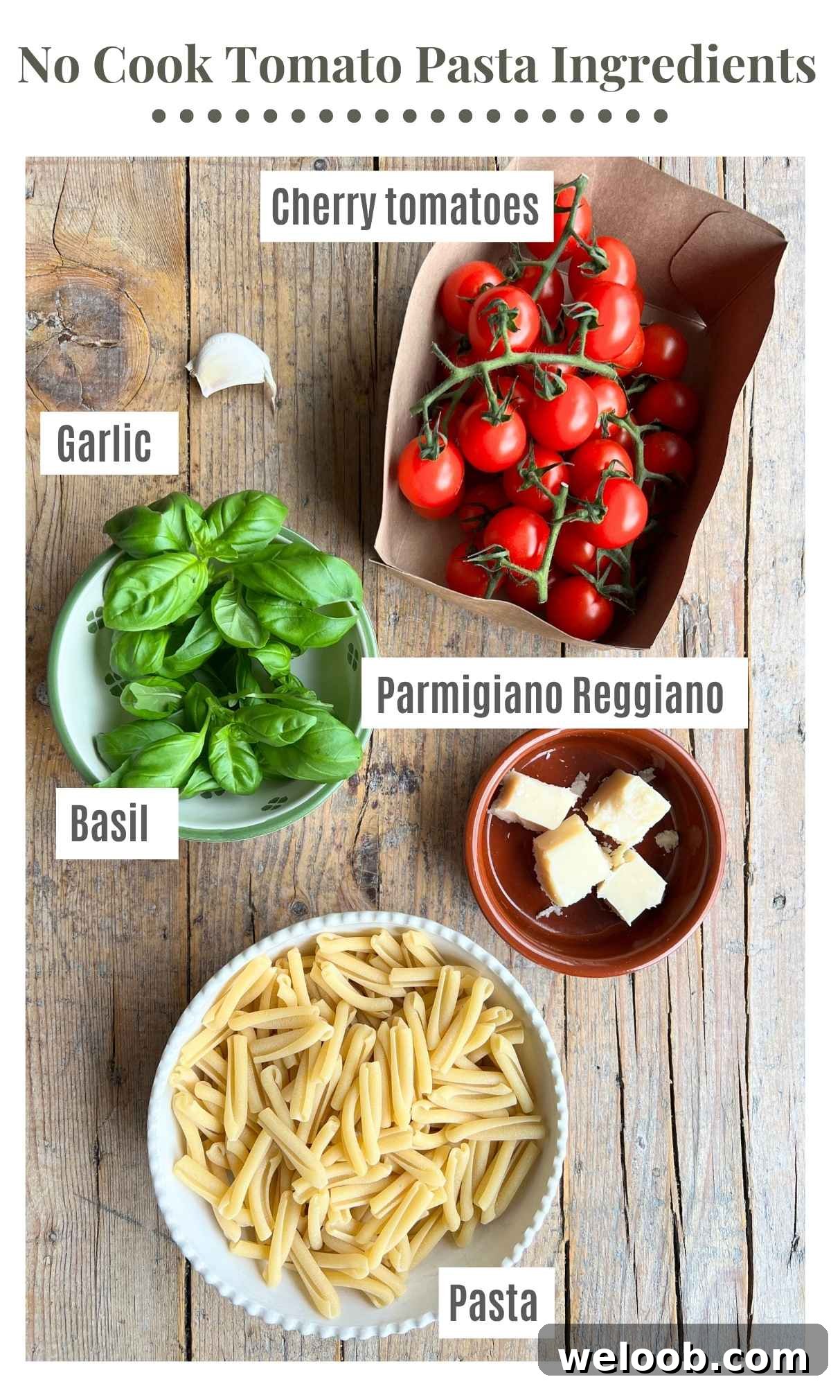 The ingredients needed to make a no cook tomato pasta laying on a rustic wooden surface; cherry tomatoes, pasta, garlic, Parmigiano Reggiano and basil.