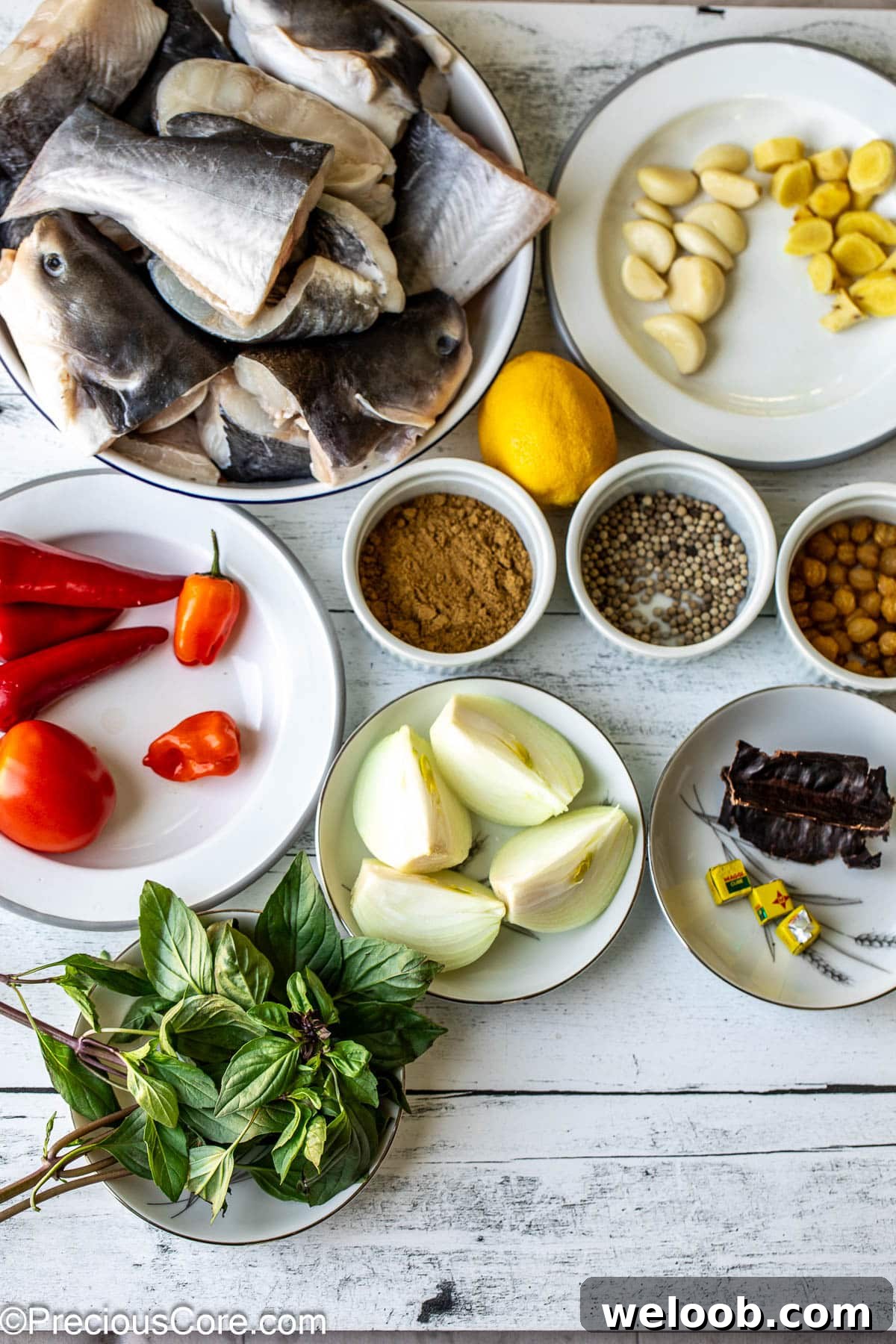 All ingredients for catfish pepper soup on a white surface.