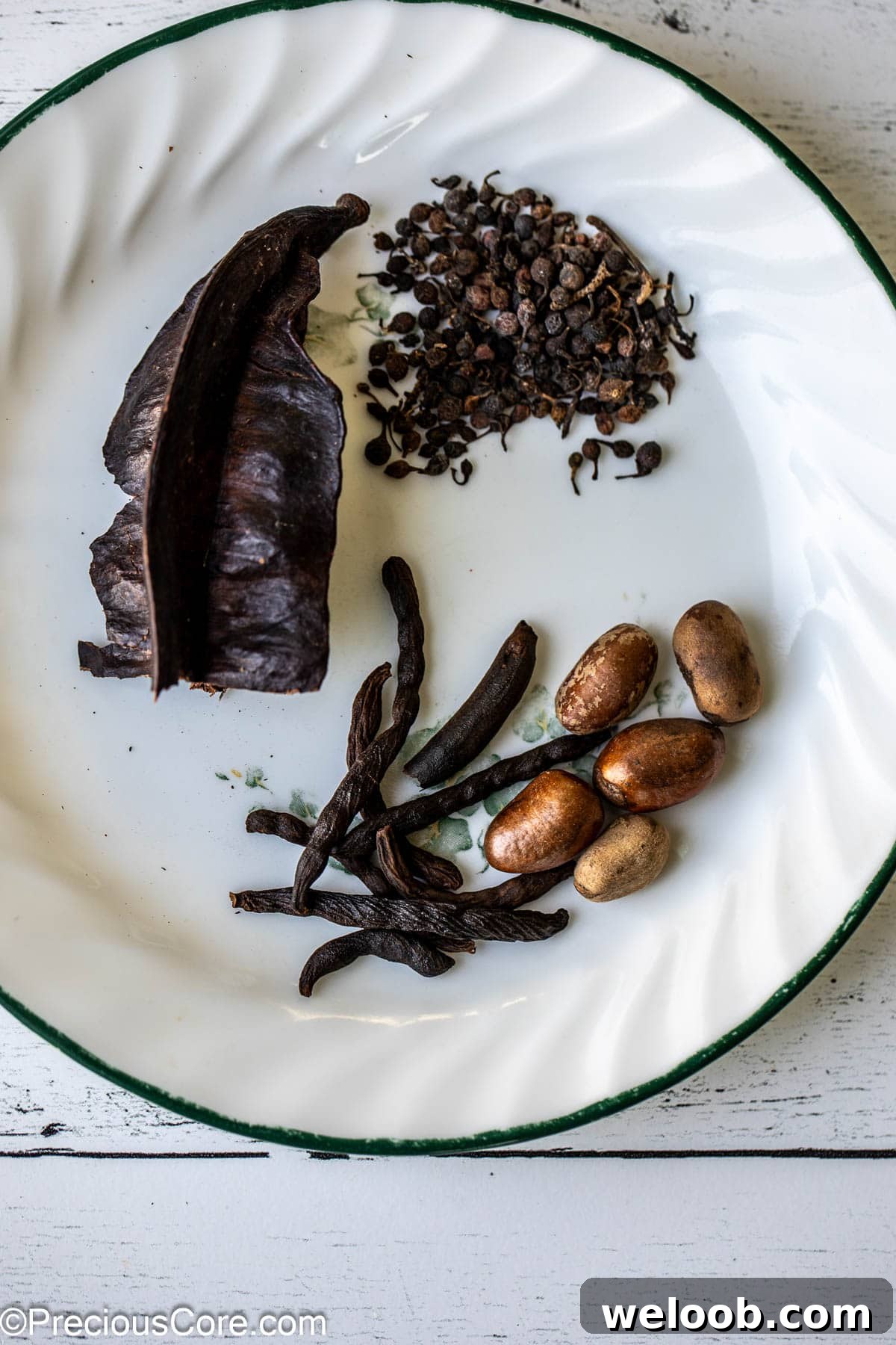 Aidan fruit, African black pepper, negro pepper, and African nutmeg on a white plate.