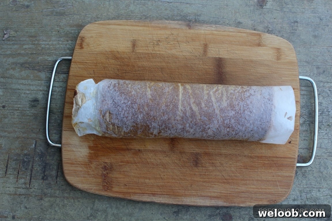 Pumpkin cake rolled on a cutting board.