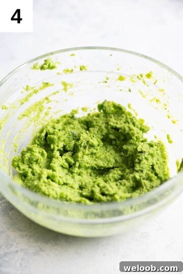 Pea pesto blitzed to a smooth paste in a small glass bowl.