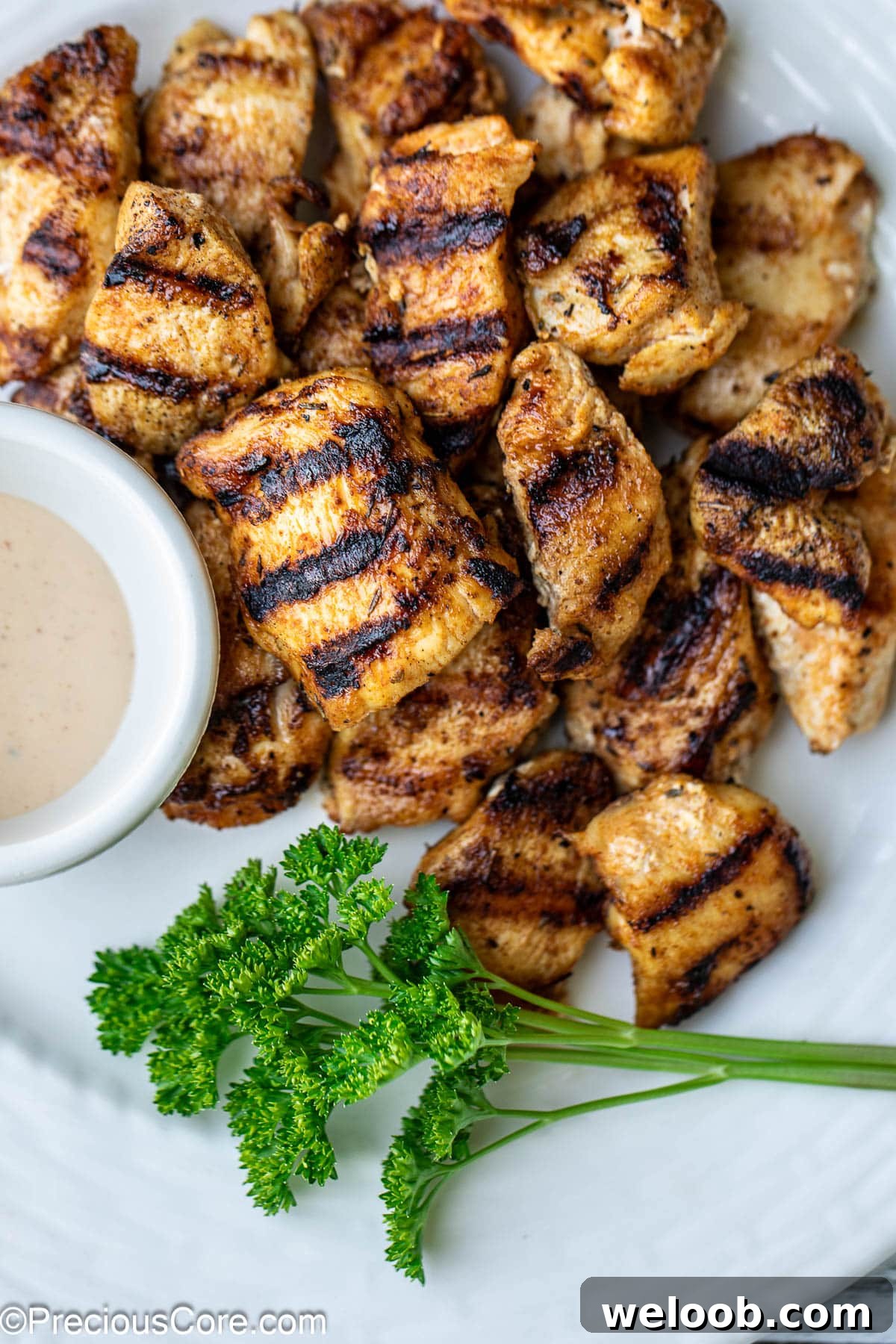 Grilled chicken nuggets with herbs and sauce.
