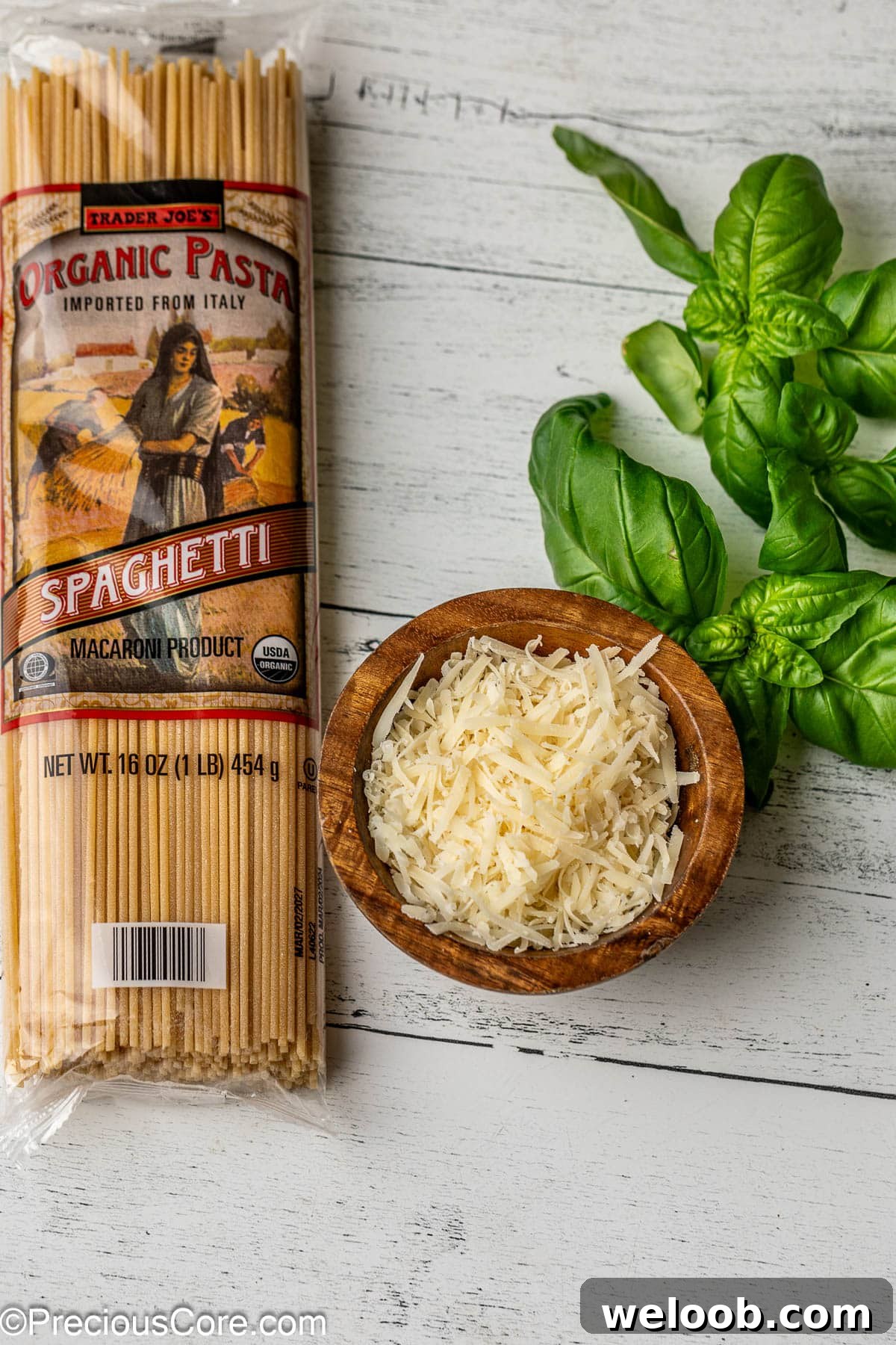 Spaghetti, shredded parmesan cheese and basil leaves.