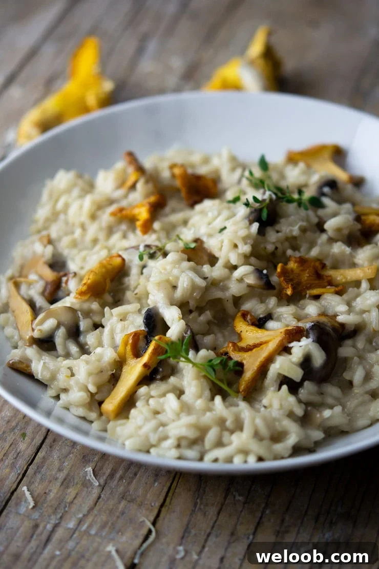 A side shot of creamy mushroom risotto in a white marble bowl