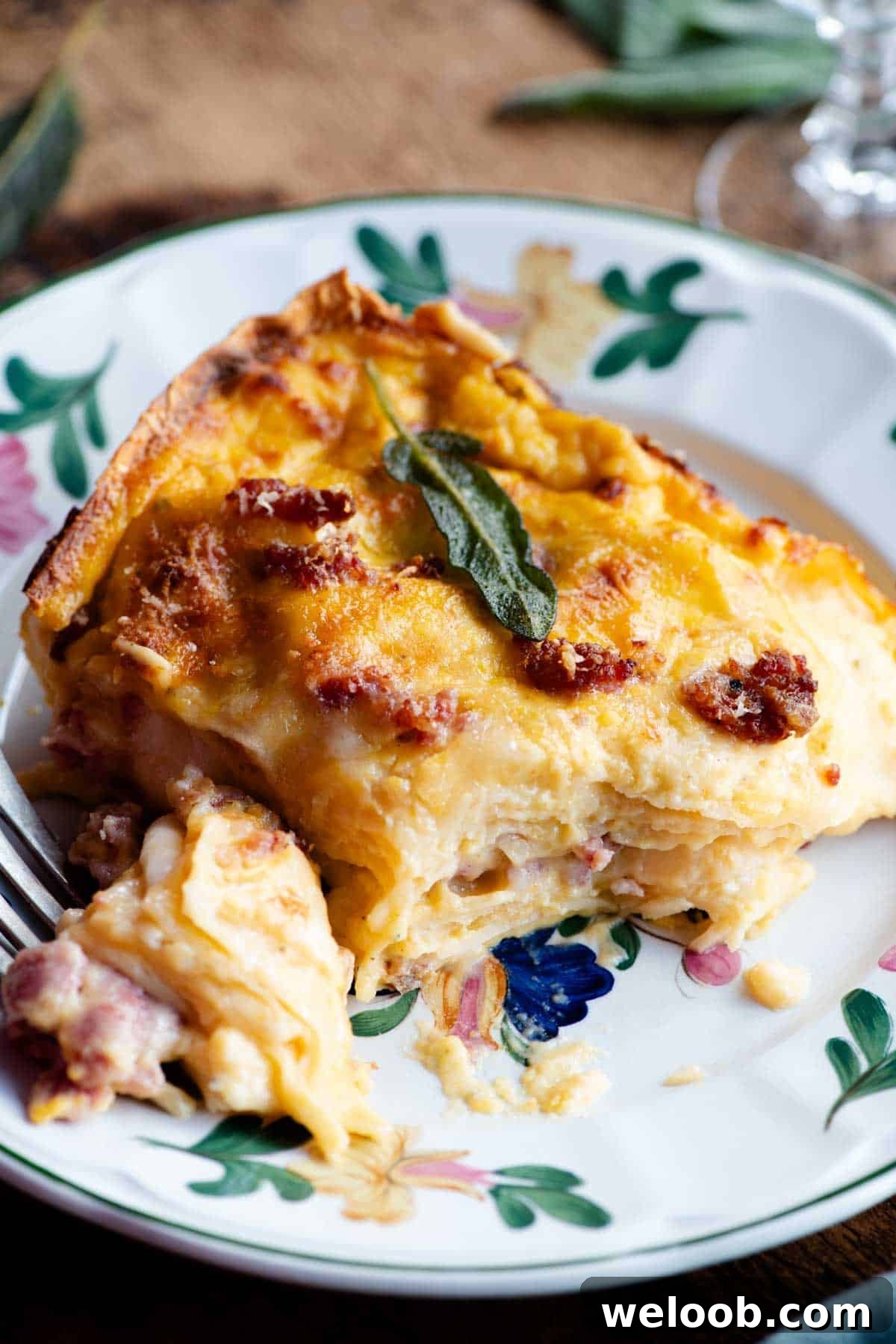 A slice of butternut squash lasagna on a floral patterned plate.