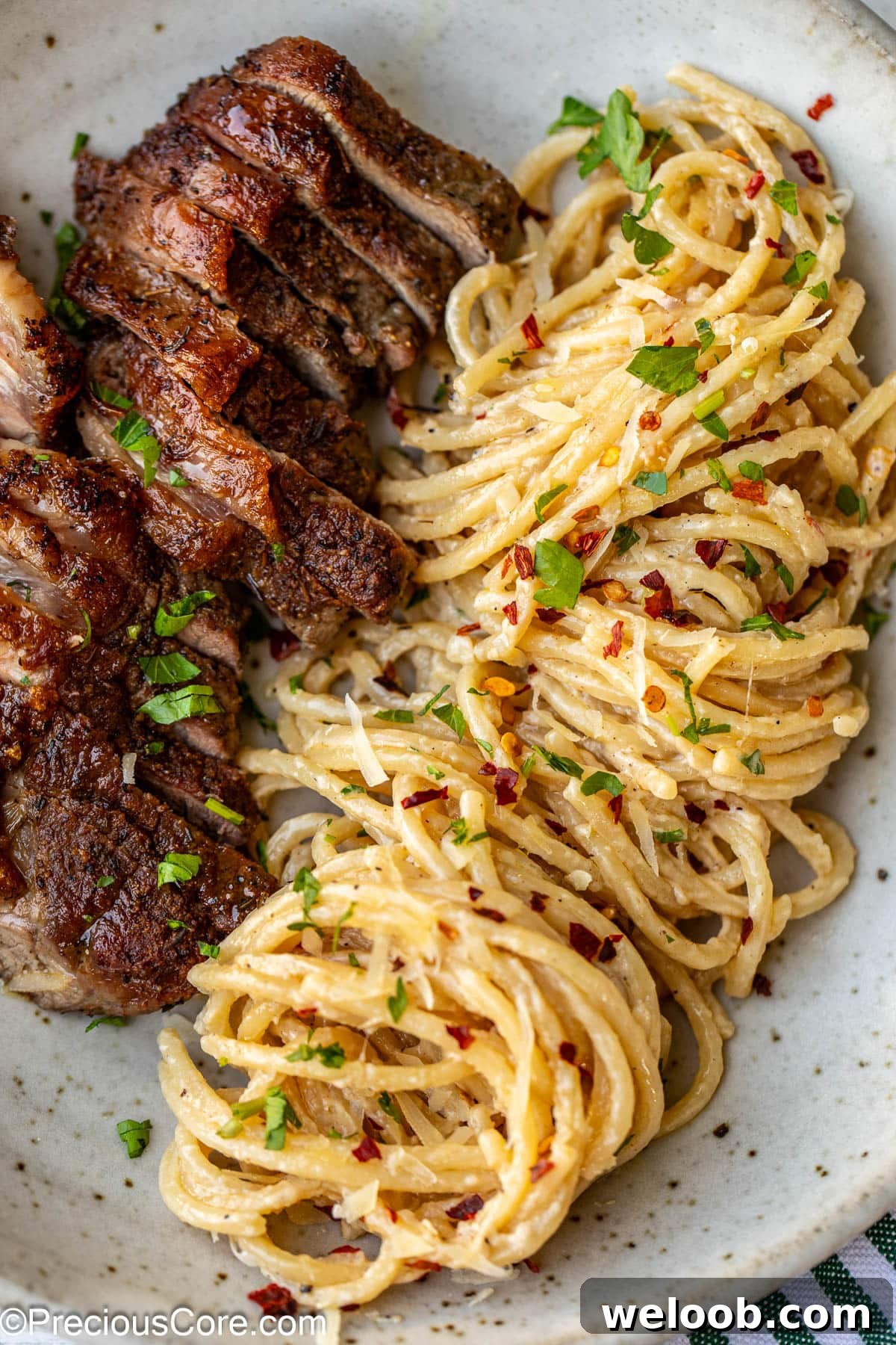 Sliced steak with cooked spaghetti in a bowl.