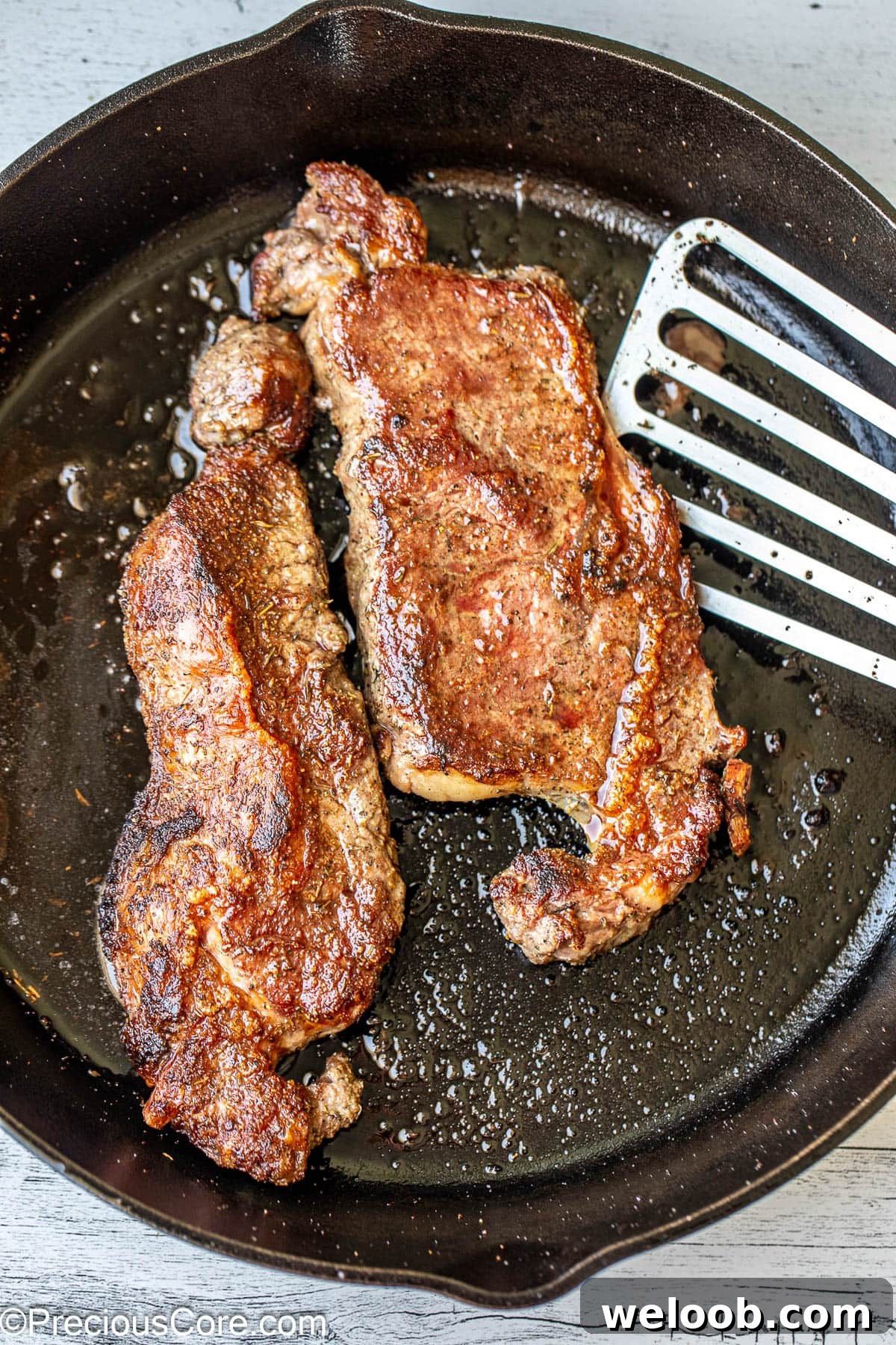 Cooking steaks in a skillet.