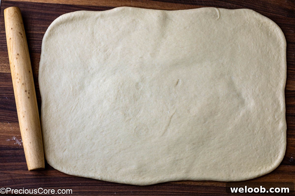 Cinnamon roll dough rolled into a rectangle.
