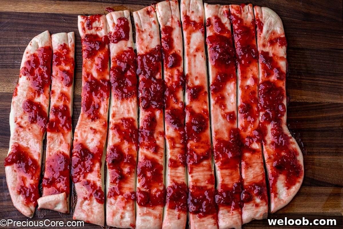 Cinnamon roll dough cut into strips.