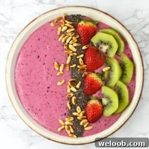 This Berry Banana Smoothie Bowl recipe is filled with delicious berries, banana, honey and is topped with chopped fruit and toasted pine nuts. www.insidetherustickitchen.com