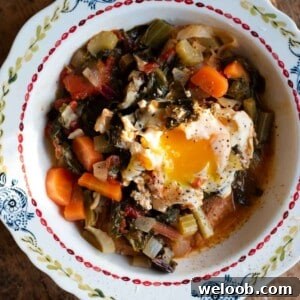 A close up cropped image of Acquacotta soup topped with a poached egg in a bowl.