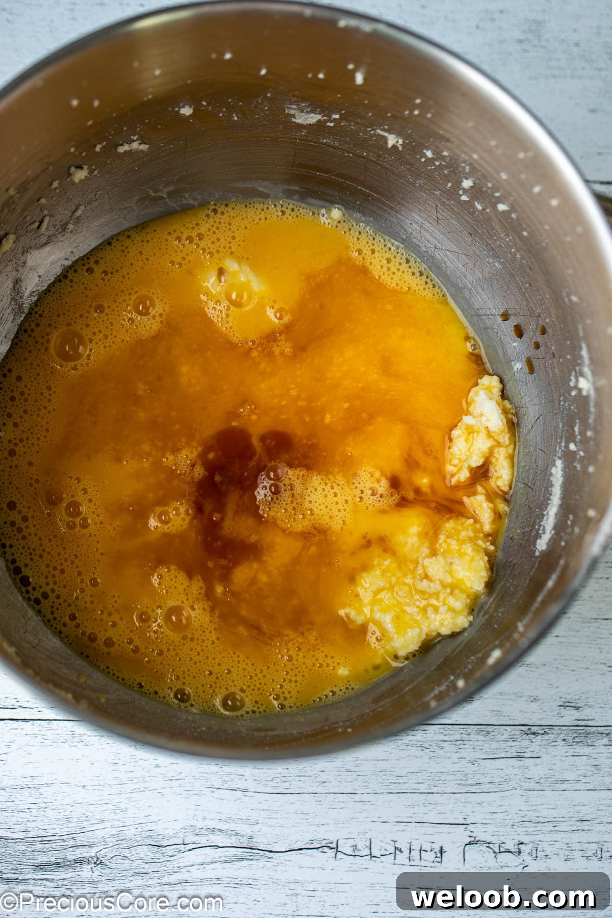 Eggs, vanilla, and other ingredients in a bowl.