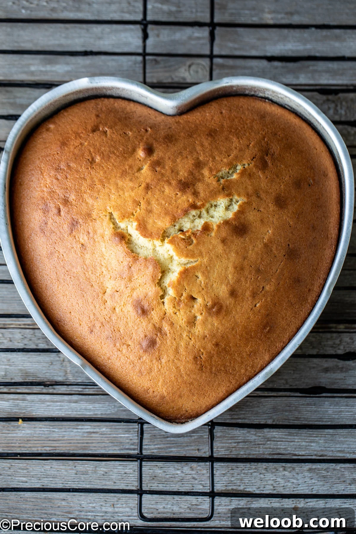 Heart shaped plain cake on a cooling rack.