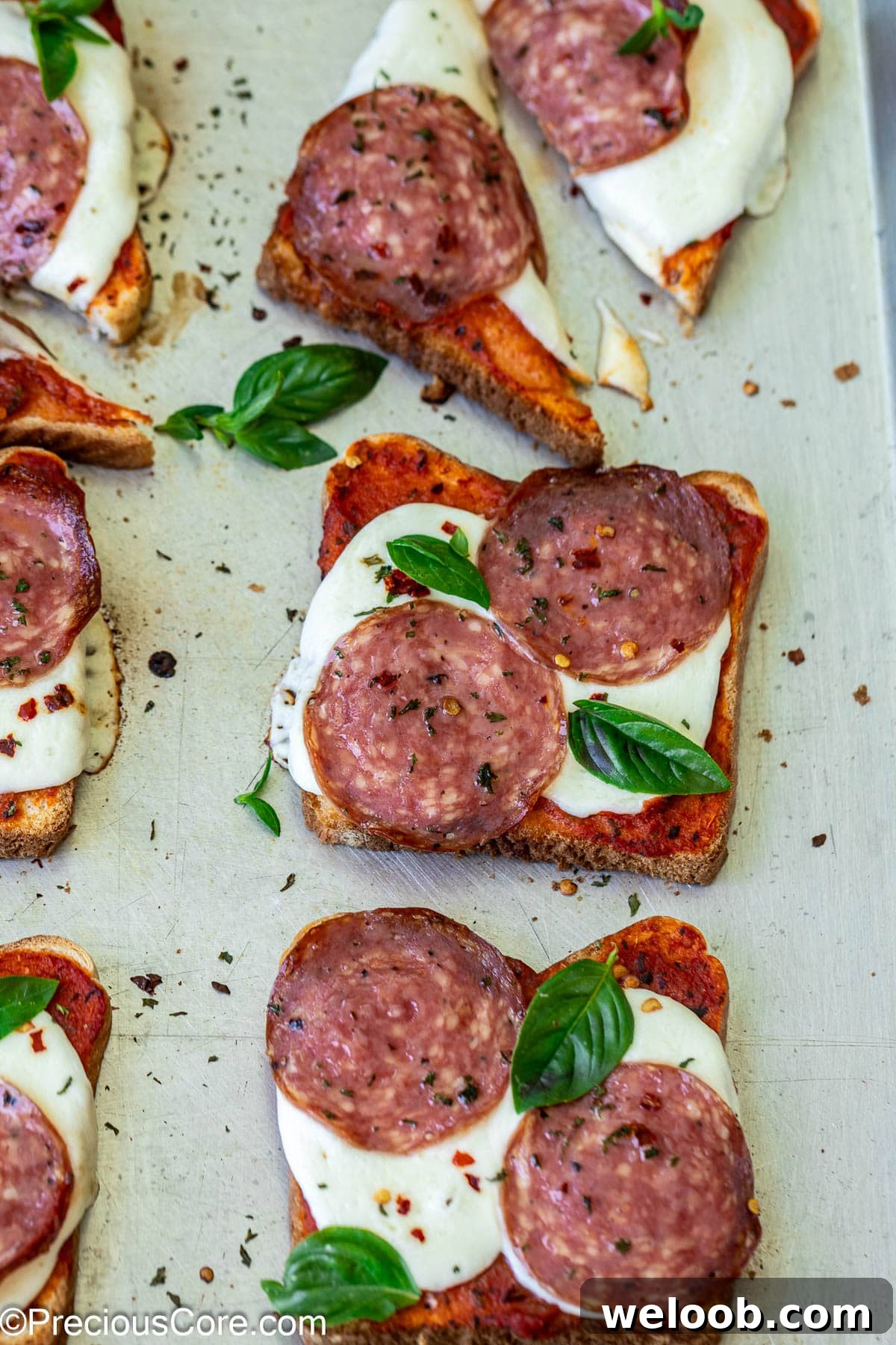 Close-up of pizza toasts on baking sheet.