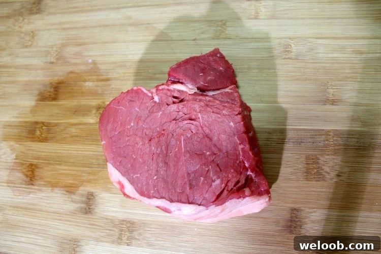 Cameroonian Soya: Grilled Skewered Beef Street Food Guide 2 Piece of top sirloin steak on a wooden cutting board.