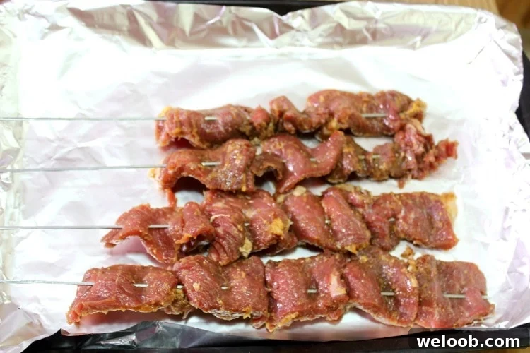 Cameroonian Soya: Grilled Skewered Beef Street Food Guide 3 Raw Cameroonian soya on a lined baking sheet.