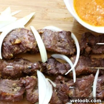 Cameroonian Soya: Grilled Skewered Beef Street Food Guide 4 Cameroonian soya on a cutting board with onions.