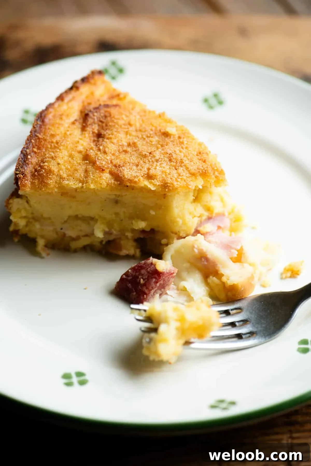 A close up of a slice of Neapolitan potato cake (gatto di patate) on a plate with a fork.