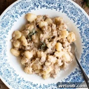 Creamy Sausage Ragu Gnocchi Recipe for Comfort Dinner 9 A close up of gnocchi with a creamy white sausage sauce with rosemary.