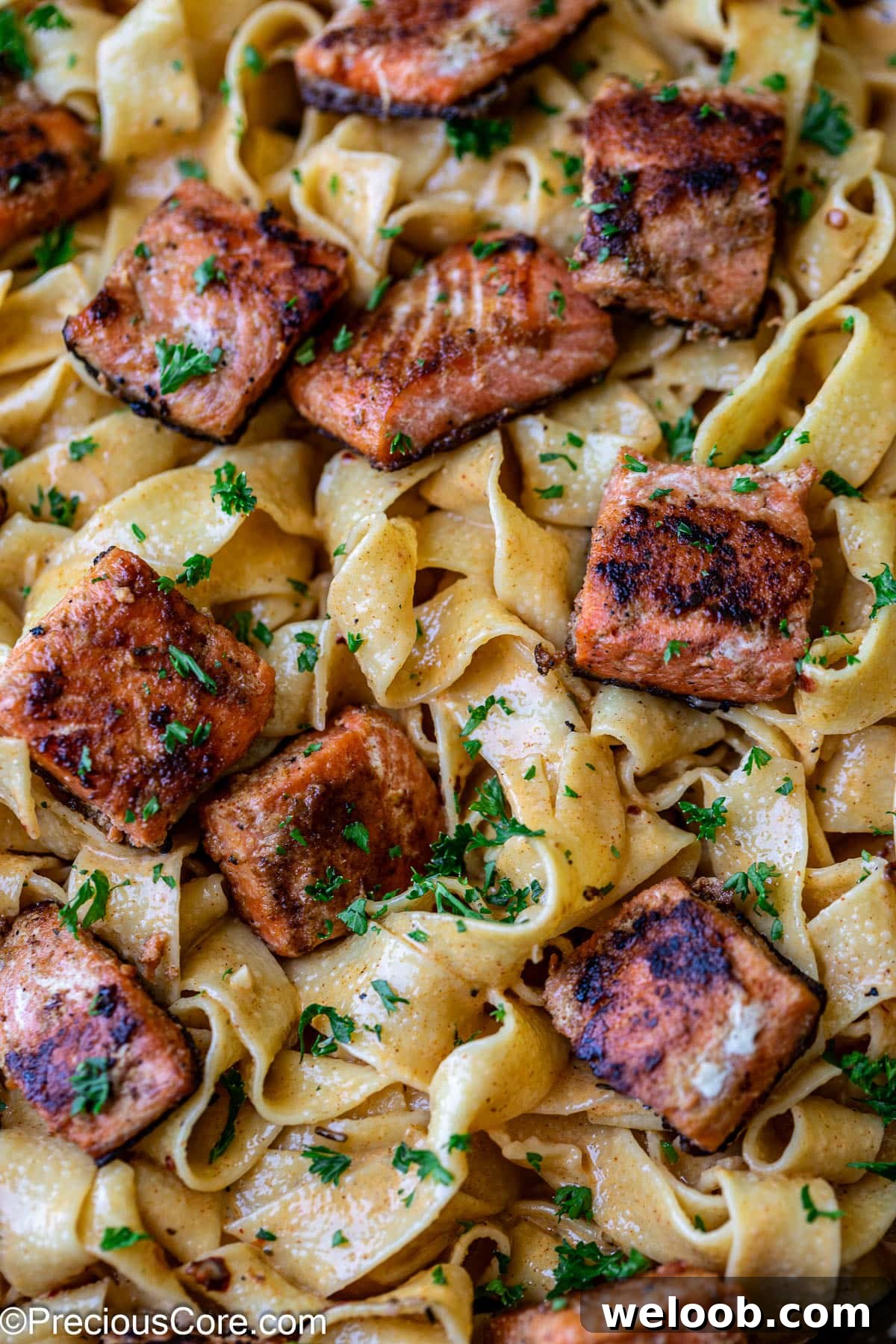 Cajun pasta with creamy sauce and salmon pieces.