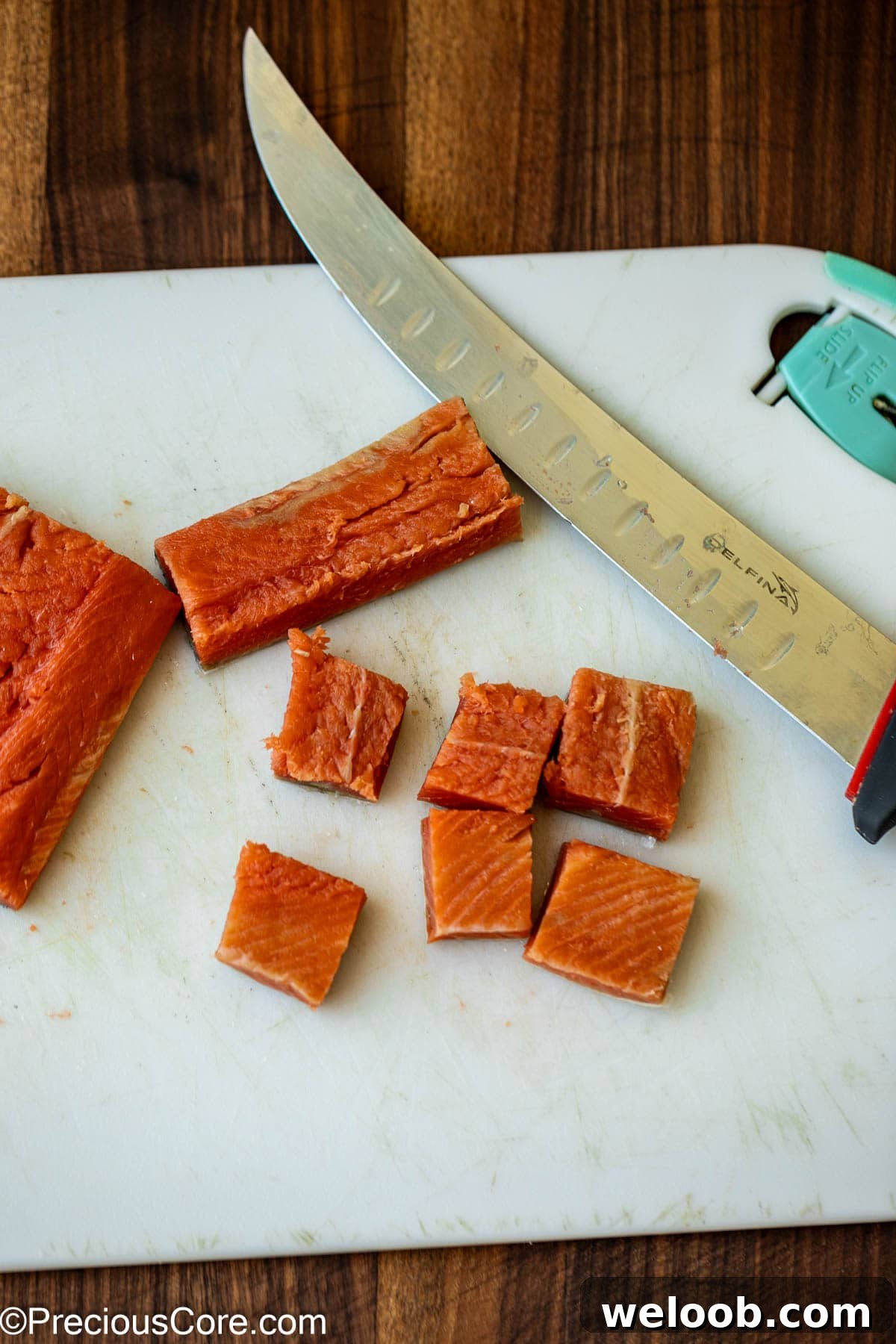 Cutting salmon into bite-sized pieces.