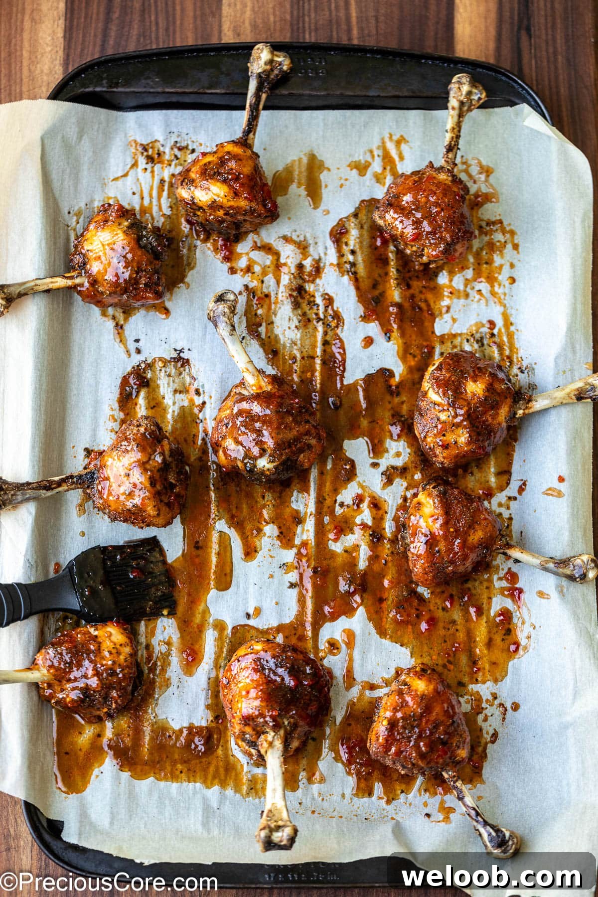 Brushing chicken lollipops with sauce.