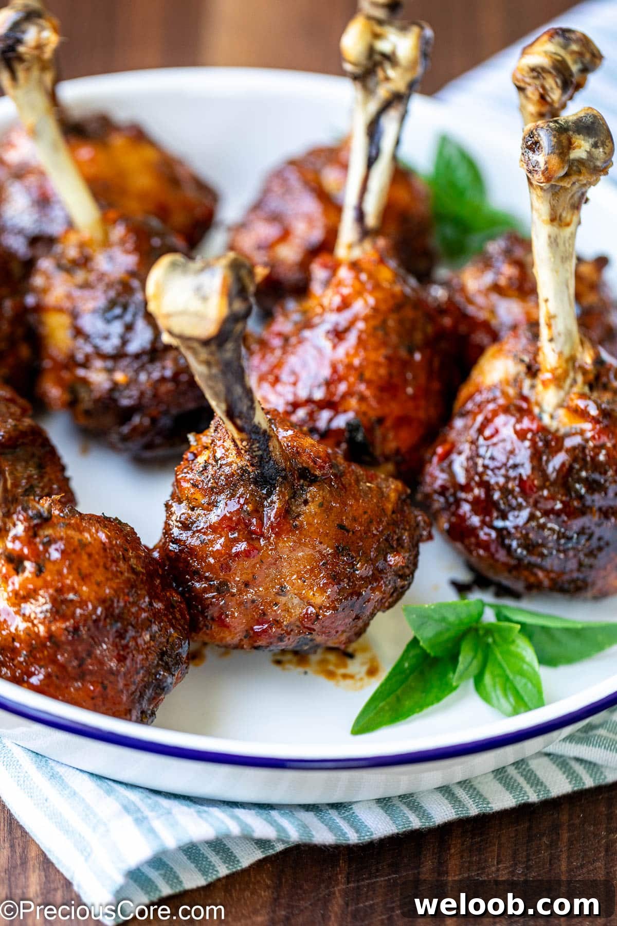 Glazed chicken drumstick lollipops with fresh herbs.