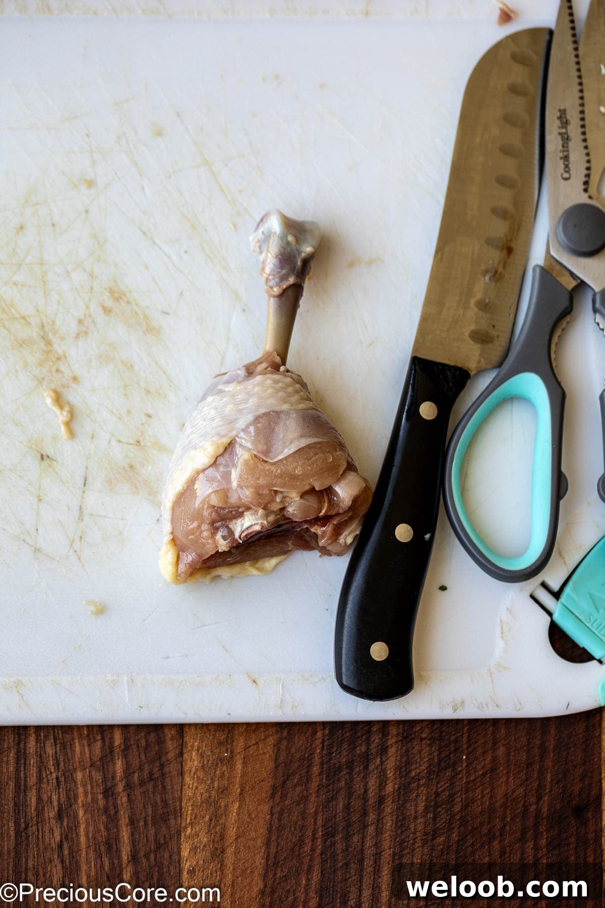 Knife, kitchen shears, and a chicken drumstick.
