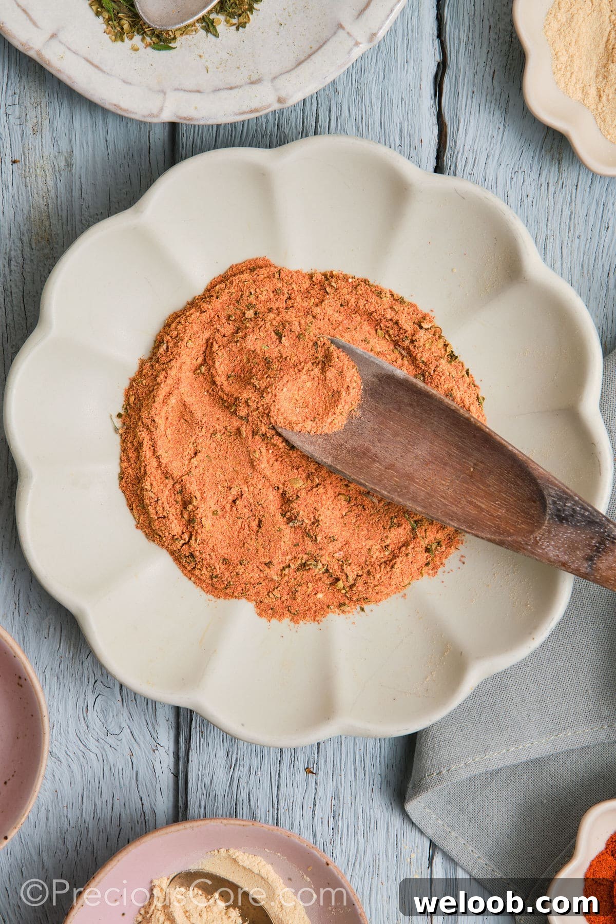 Wooden spoon in a plate of Cajun seasoning substitute.