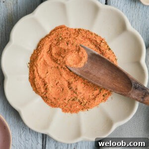 Wooden spoon in a plate of Cajun seasoning substitute.