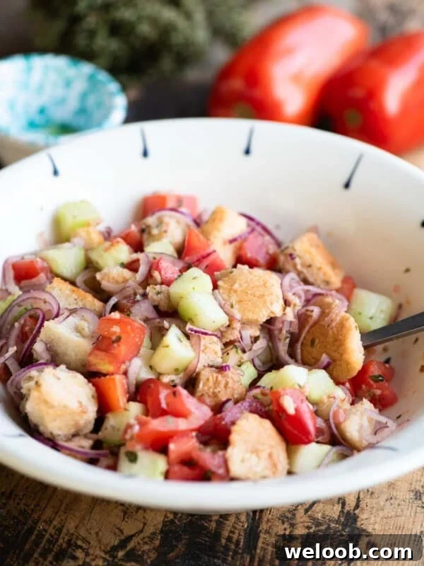 Cialledda salad in a white bowl sitting on a wooden surface.