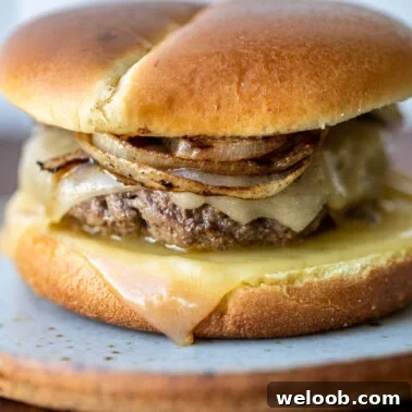 Square image of a grilled onion cheddar burger.