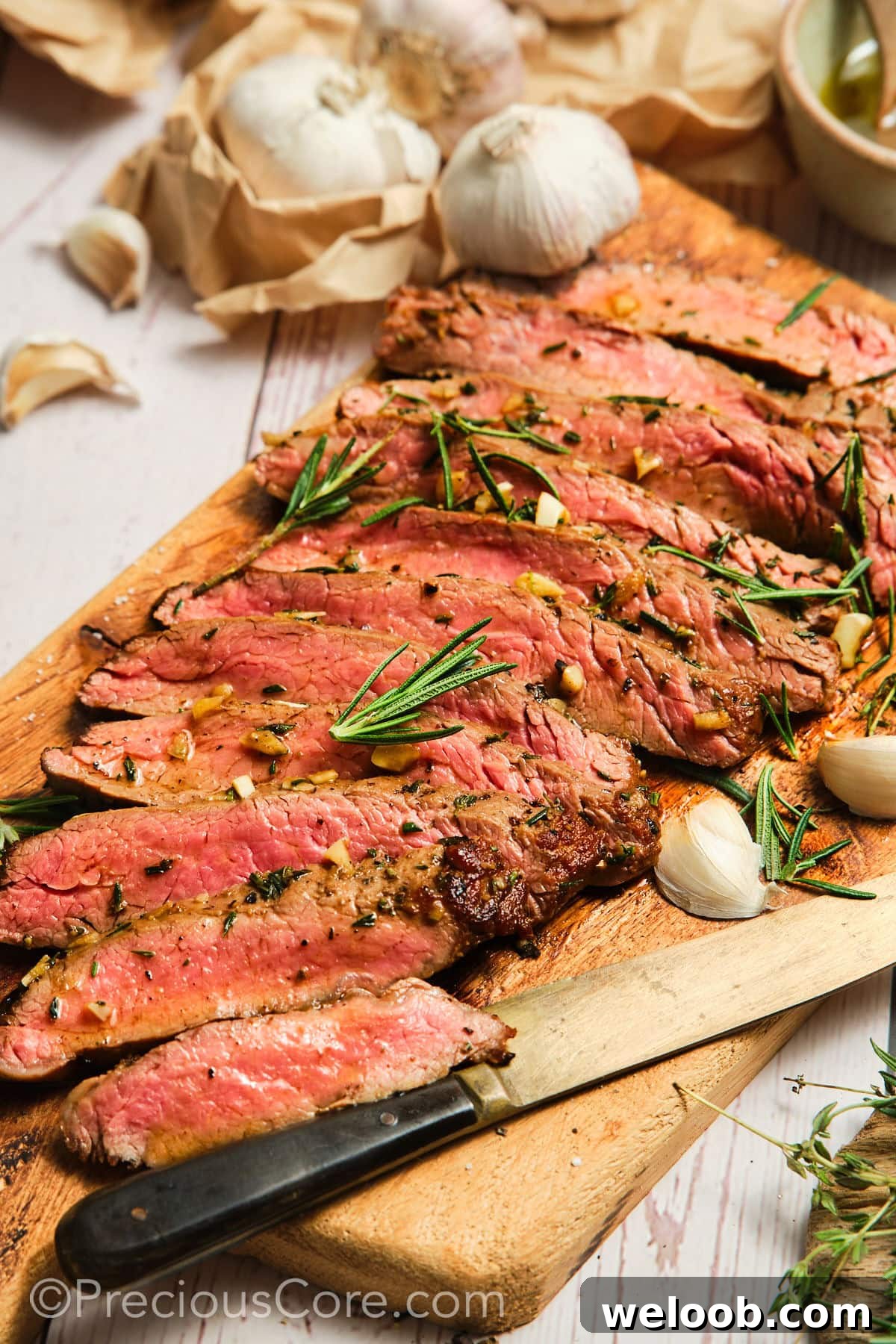 Sliced pan seared flank steak on a cutting board.