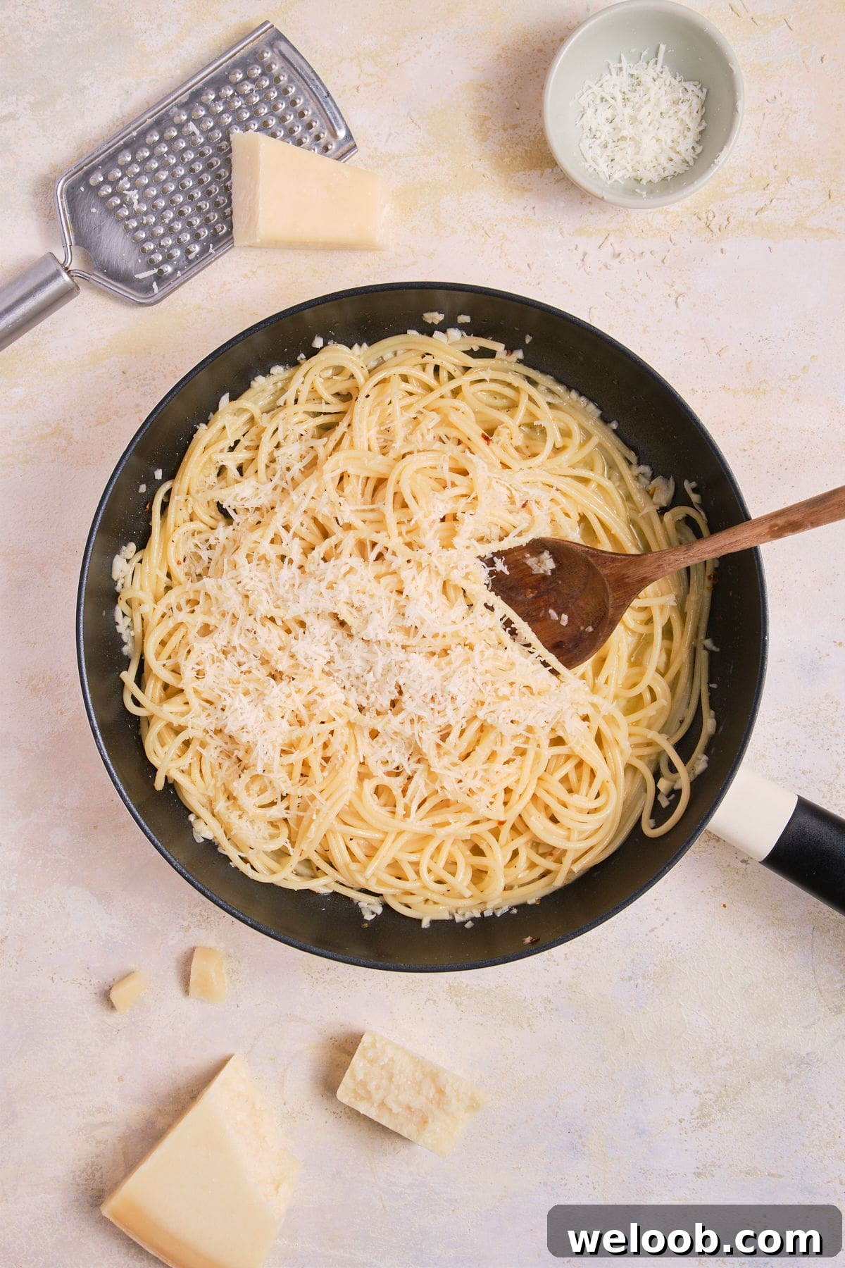 Parmesan added to lemon garlic butter pasta.